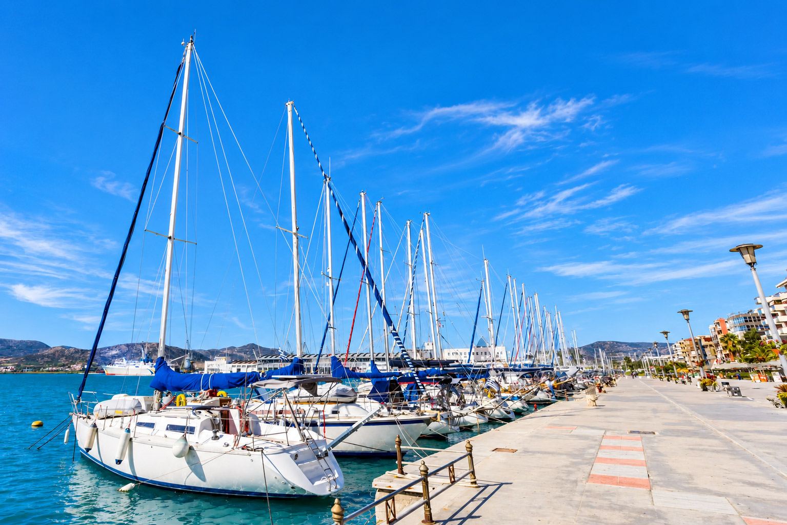 Porto turistico con pontili pieni di imbarcazioni in riva al mare